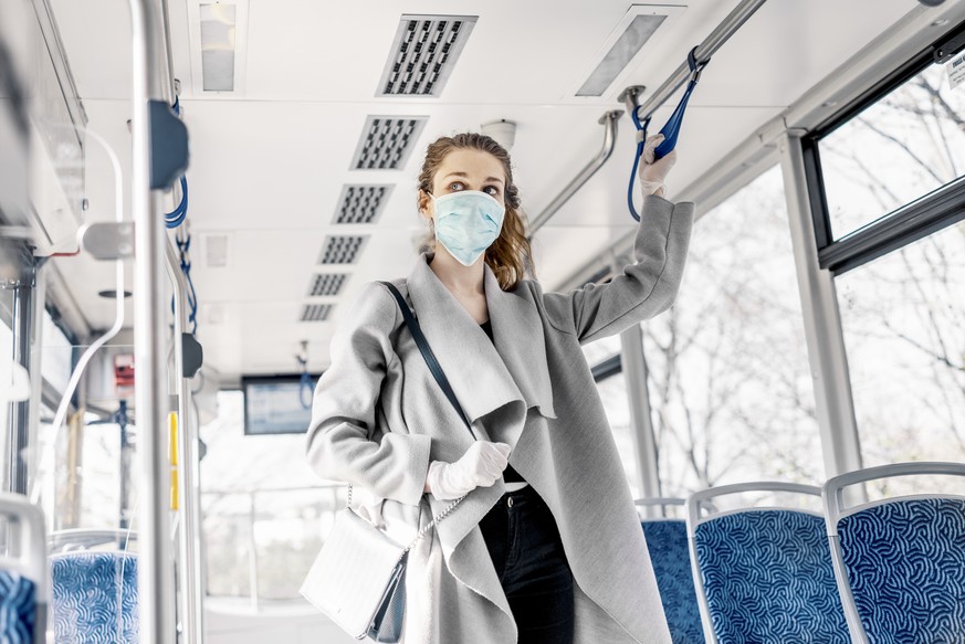 Woman wearing surgical protective mask going to work