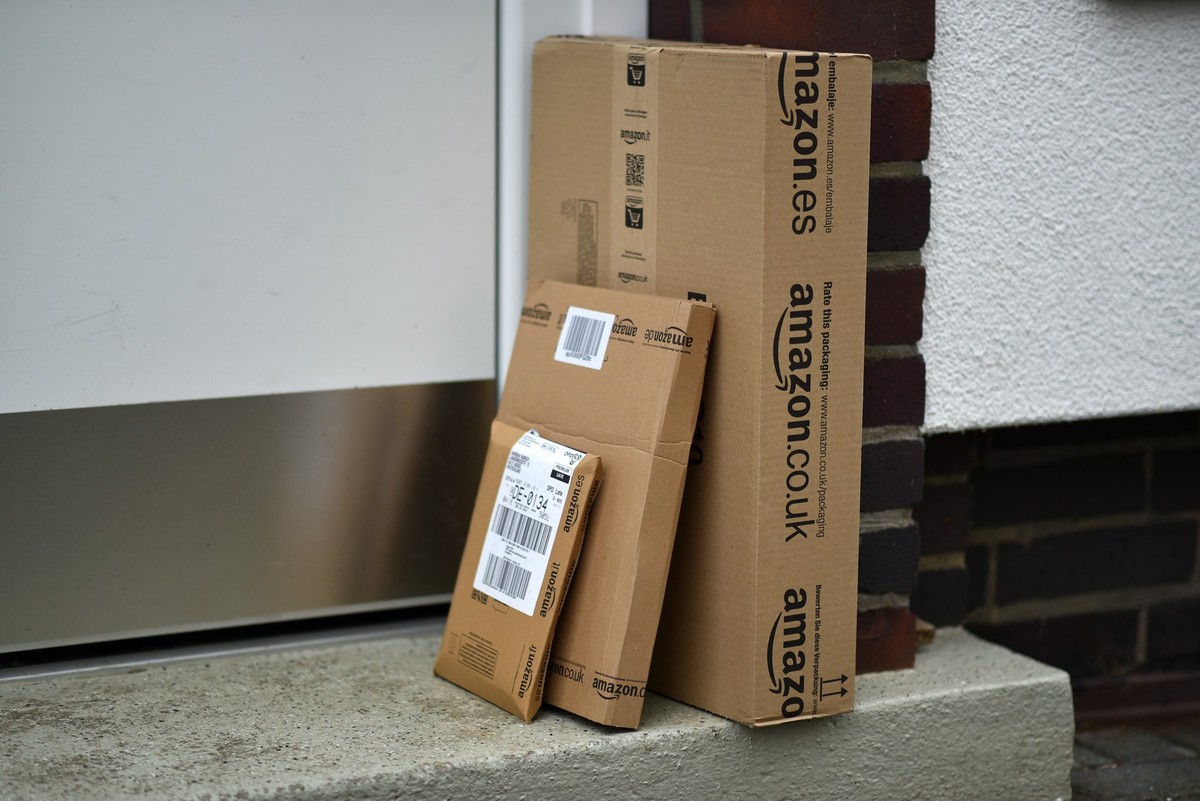 ARCHIV - 20.12.2014, Hessen, Kassel: ILLUSTRATION - Päckchen des Online-Versandhändlers Amazon stehen vor einer Haustür. Deutschlands Paketbranche setzt immer stärker darauf, die Sendungen bei der Zus ...