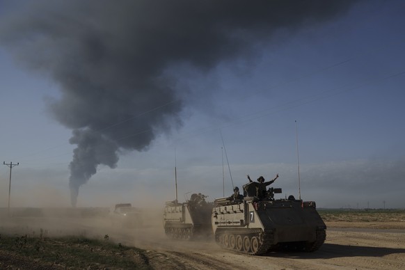 FILE - Israeli soldiers move on armored personnel carriers (APC) near the Israeli-Gaza border as smoke rises to the sky in the Gaza Strip, seen from southern Israel on Jan. 21, 2024. (AP Photo/Leo Cor ...