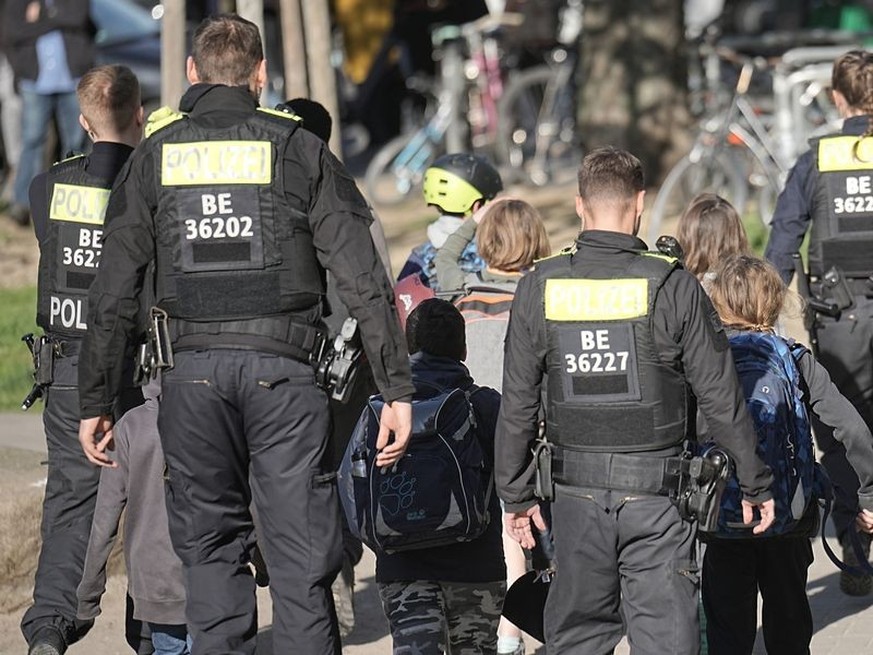 dpatopbilder - Polizisten geleiten Kinder von einer Schule in Neukölln weg. Foto: Michael Kappeler/dpa