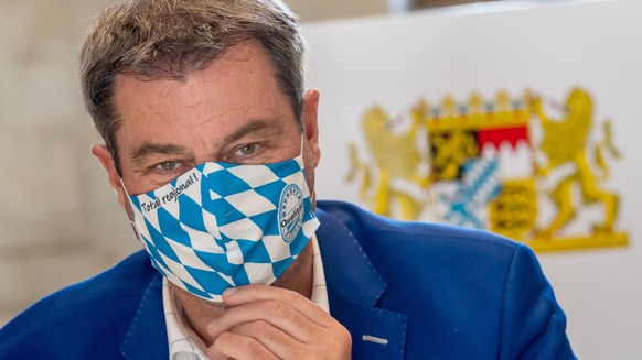 ARCHIV - 21.07.2020, Bayern, München: Markus Söder (CSU), Ministerpräsident von Bayern, trägt zu Beginn der Kabinettssitzung in der Bayerischen Staatskanzlei eine Mundschutzmaske im weiß-blauem Rauten ...