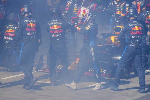 Red Bull driver Max Verstappen of the Netherlands walks from his car as it is enveloped in smoke as he retires from the Australian Formula One Grand Prix at Albert Park, in Melbourne, Australia, Sunda ...