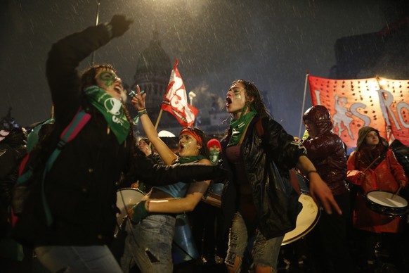 Women in support of decriminalizing abortion protest in the rain outside Congress where lawmakers are debating the issue in Buenos Aires, Argentina, Wednesday, Aug. 8, 2018. The Senate is debating a b ...