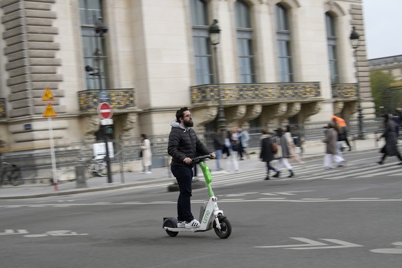 A man rides a scooter in Paris, Friday, march 31, 2023. Romantically zipping two-to-a-scooter, wind in the hair, past the Eiffel Tower and other iconic sights could soon become a thing of the past if  ...