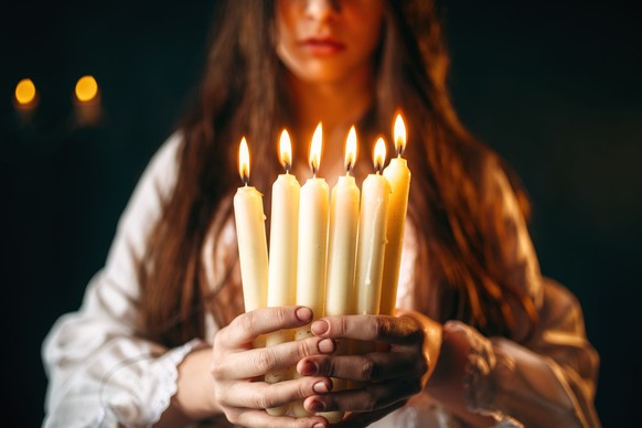 Female person holds candles in hands, divination model released