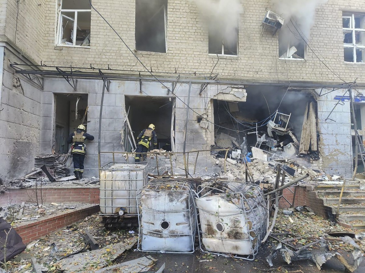 In this photo provided by the Ukrainian Emergency Service, emergency services workers look to move rubble and find injured after Russian attacks on a medical center in the northeastern Ukrainian city  ...