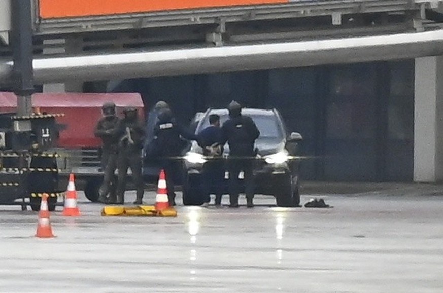 04.11.2023, Hamburg: Ein Mann wird auf dem Flughafen von der Polizei weggeführt. Ein bewaffneter Mann hattee auf dem Airport seine vierjährige Tochter in seiner Gewalt gehalten. Foto: Jonas Walzberg/d ...