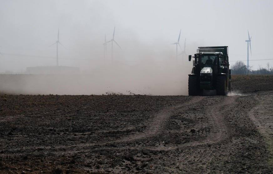 Ein Traktor bringt Dünger auf einen Acker bei Zörbig aus, wobei als Folge von Dürre und Trockenheit viel Staub aufgewirbelt wird. Am Mittwoch (30.03.2022) beginnt die Agrarministerkonferenz unter Vors ...