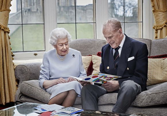 Queen Elizabeth II. und ihr Ehemann Prinz Philip im November 2020. Sie sehen sich selbstgebastelte Hochzeitstagskarten ihrer Urenkel an.