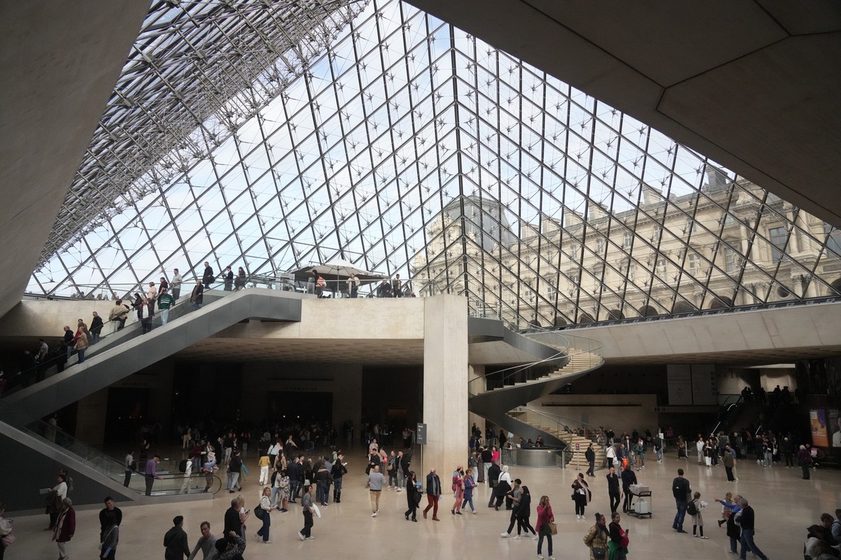 Visitors walk in the lobby of the Louvre museum three days after historic jewels were stolen in a daring daylight heist, Wednesday, Oct. 22, 2025 in Paris. (AP Photo/Thibault Camus)