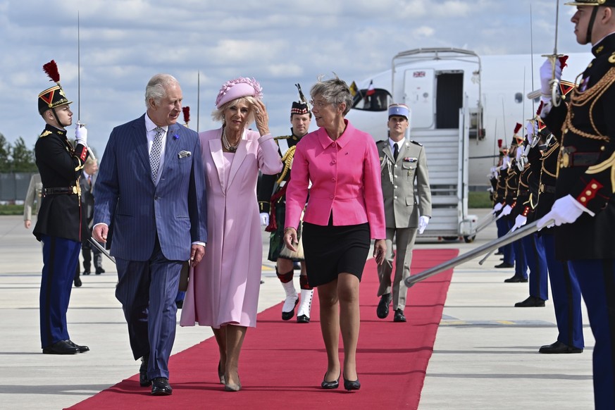 20.09.2023, Frankreich, Orly: Der britische König Charles III. und Königin Camilla werden von Elisabeth Borne (r), Premierministerin von Frankreich, auf dem Flughafen Orly südlich von Paris empfangen. ...