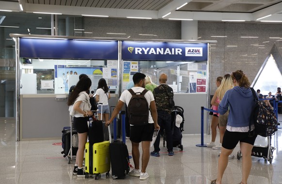 24.06.2022, Spanien, Palma: Passagiere stehen am Schalter von Ryanair auf dem Flughafen von Palma de Mallorca. Das Kabinenpersonal von Ryanair beginnt heute in einigen L�ndern einen Streik wegen der A ...