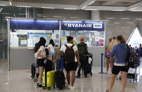 24.06.2022, Spanien, Palma: Passagiere stehen am Schalter von Ryanair auf dem Flughafen von Palma de Mallorca. Das Kabinenpersonal von Ryanair beginnt heute in einigen L