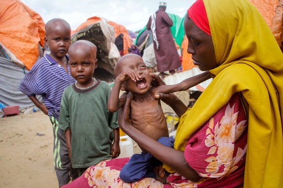ACHTUNG: SPERRFRIST 16. OKTOBER 18:57 UHR. - ARCHIV - 03.09.2022, Somalia, Mogadischu: Maryan Madey, die aus der von Dürre heimgesuchten Region Lower Shabelle geflohen ist, hält ihre unterernährte Toc ...