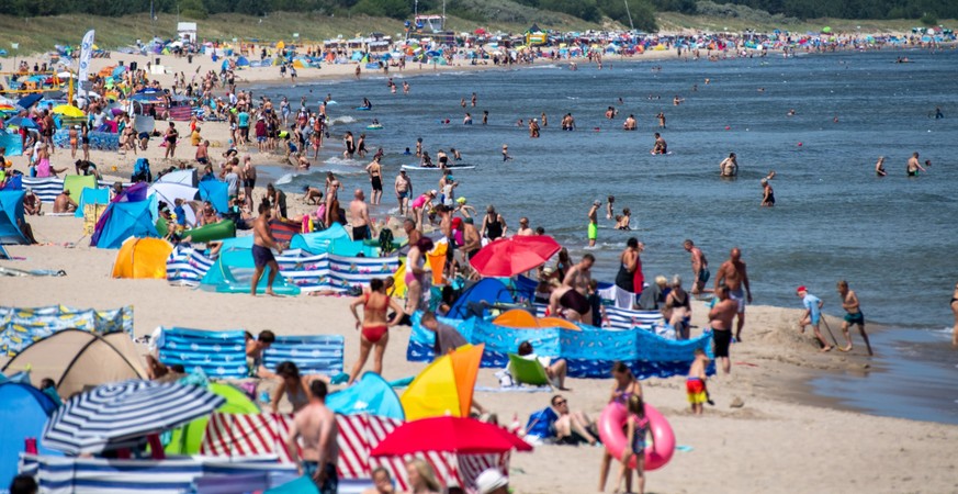 16.07.2023, Mecklenburg-Vorpommern, Zinnowitz: Zahlreiche Menschen sind bei sonnigem Wetter am Strand der Insel Usedom unterwegs. In den meisten Regionen gibt es heute einen Sonne-Wolken-Mix. Nur im S ...