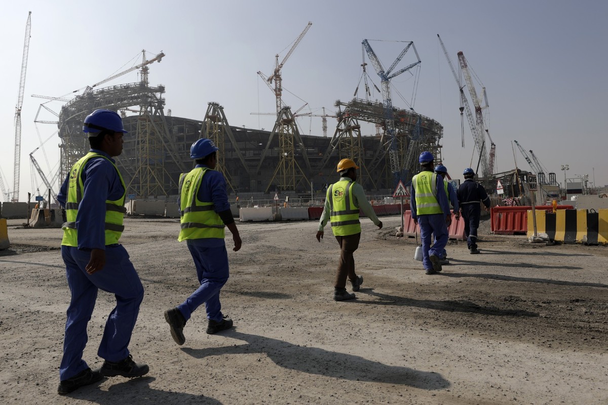 FILE - Workers walk to the Lusail Stadium, one of the 2022 World Cup stadiums, in Lusail, Qatar, Friday, Dec. 20, 2019. Paris has decided not to display the matches of the World Cup in Qatar on giant ...