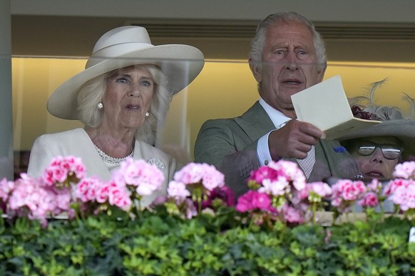 20.06.2023, Großbritannien, Ascot: König Charles III. und Königin Camilla von Großbritannien reagieren, nachdem ihr Pferd Saga am ersten Tag des Royal Ascot Pferderennens auf der Pferderennbahn Ascot  ...