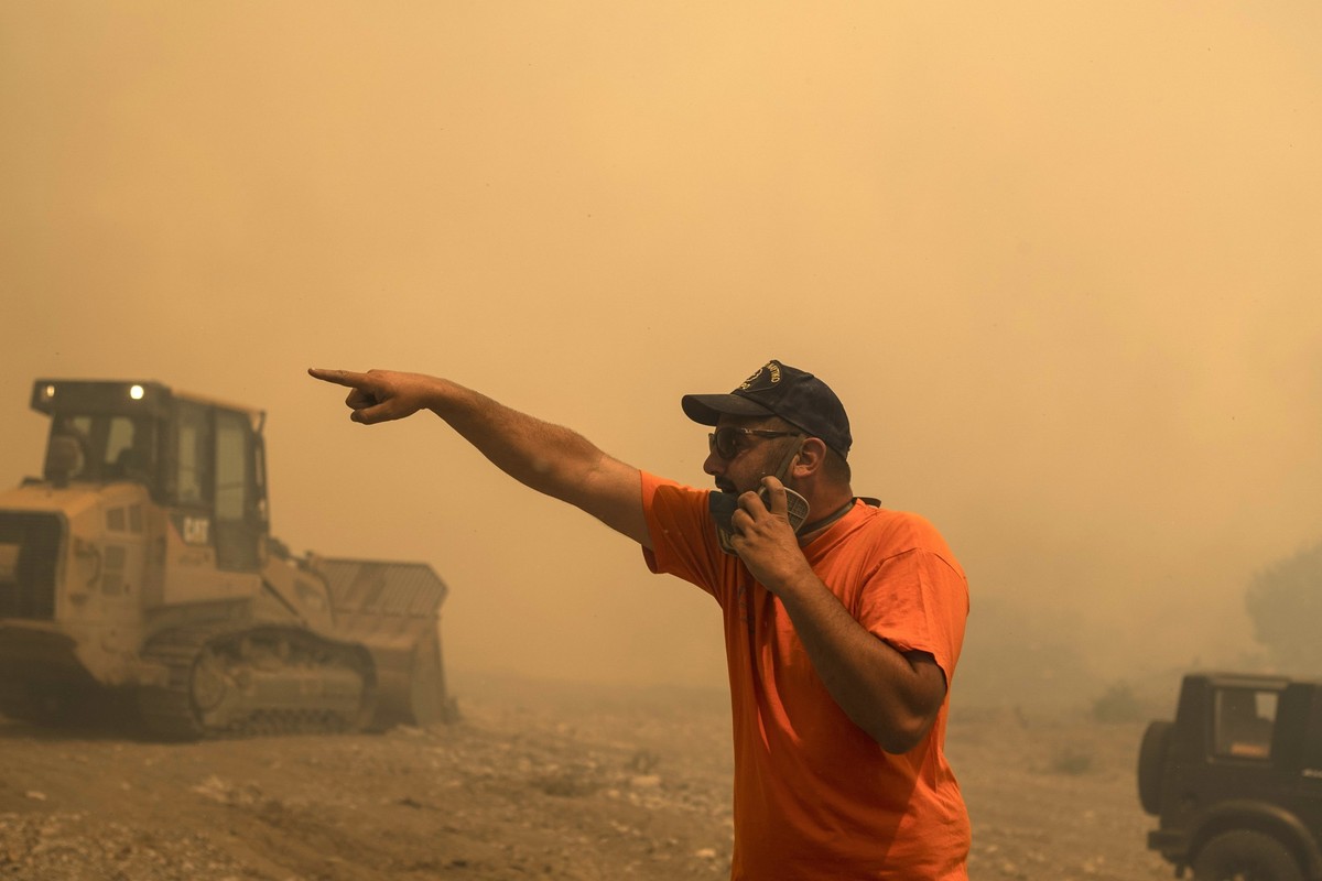 25.07.2023, Griechenland, Rhodos: Ein Freiwilliger Helfer gibt während eines Waldbrandes im Dorf Vati Anweisungen. Starke Winde erschweren den Kampf gegen die Waldbrände auf der griechischen Ferienins ...