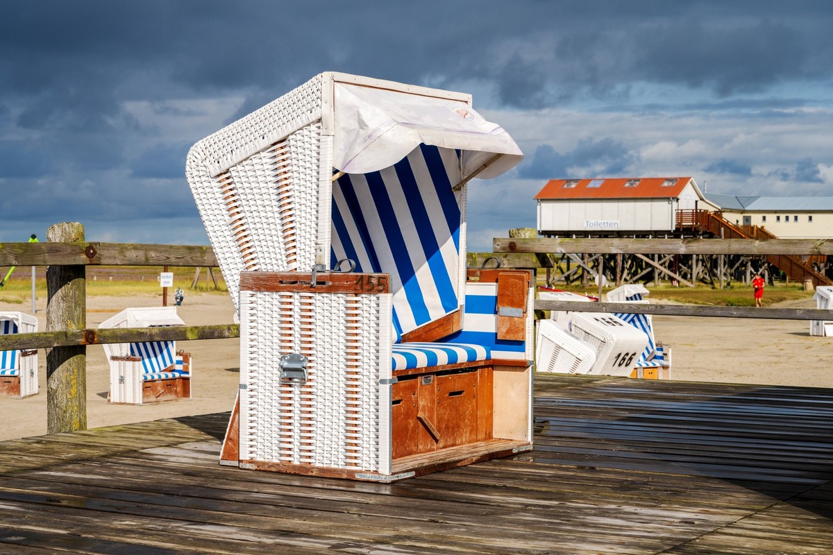 Strand mit Pfahlbauten und Strandkörben im Sommer in St. Peter Ording *** Beach with pile dwellings and beach chairs in summer in St Peter Ording