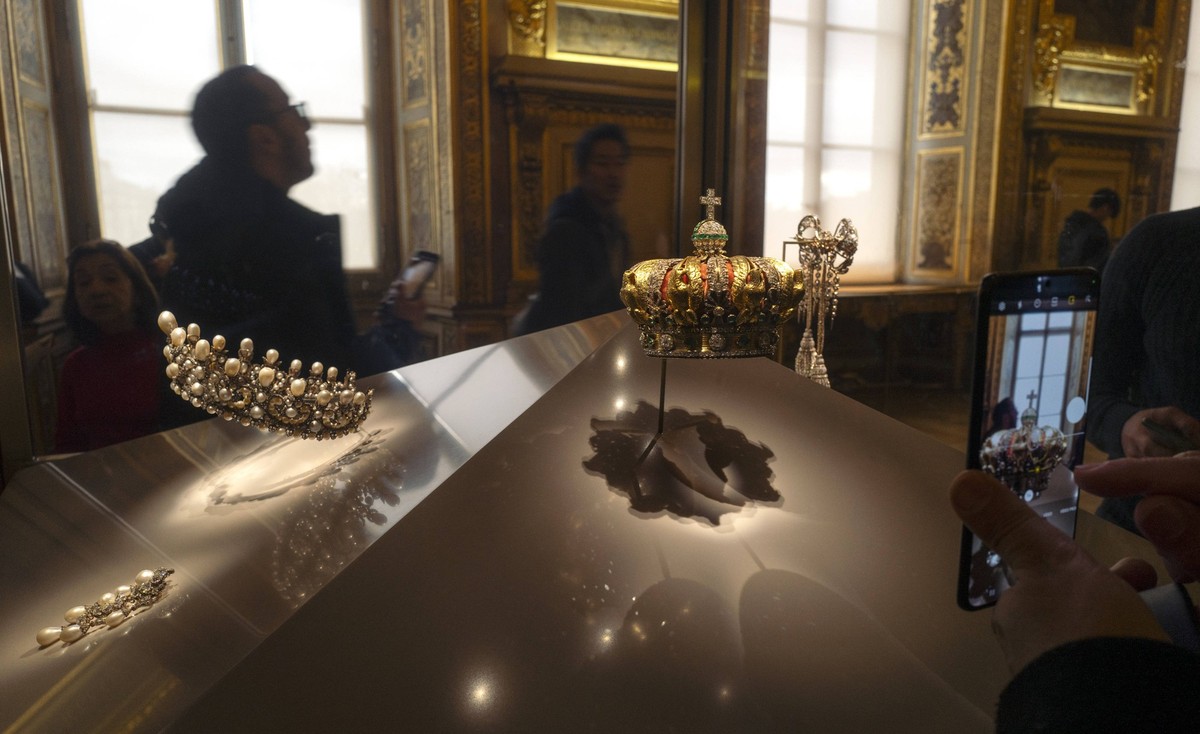 Museum goers inside the golden room which holds the French Crown Jewels in the Louvre Museum in Paris a photograph from January 6, 2022. Four thrives broke into the Louvre Museum on Sunday, October 19 ...