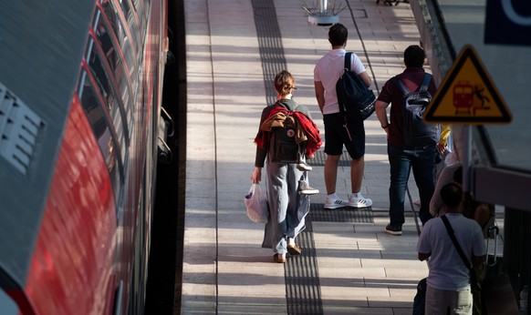 11.06.2022, Hamburg: Reisende sind auf dem Hauptbahnhof auf einem Bahnsteig neben einem Regionalzug unterwegs. Foto: Daniel Reinhardt/dpa +++ dpa-Bildfunk +++