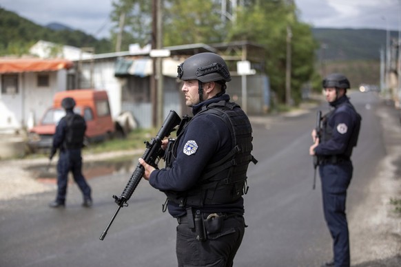 25.09.2023, Kosovo, Zvecan: Kosovarische Polizisten sichern die Straße, die zum Banjska-Kloster führt, während eines laufenden Polizeieinsatzes. Nach schweren Gefechten mit Toten hat die kosovarische  ...