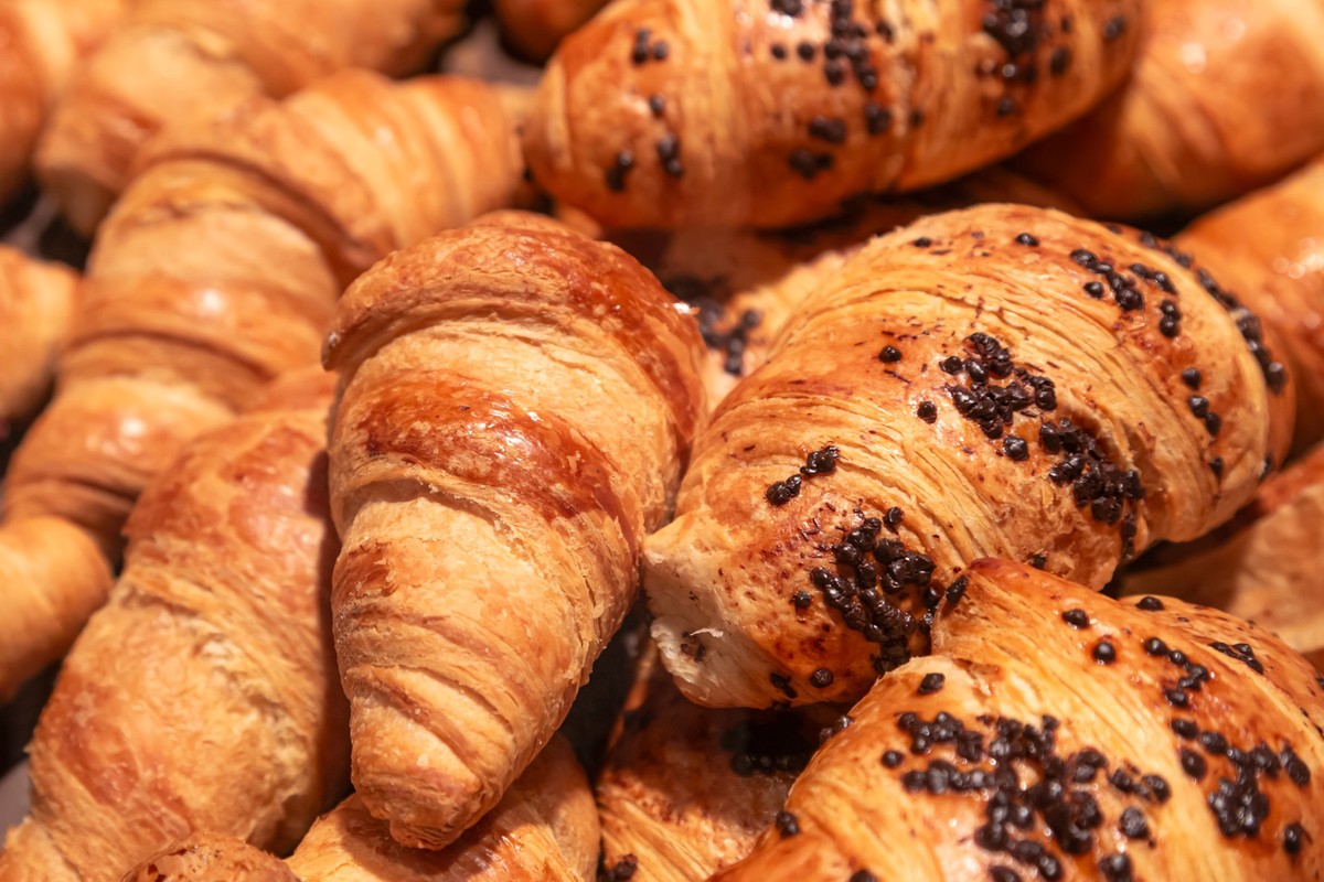 Close-up, croissants on a counter in a supermarket. Food baking background. Showcase of a pastry shop or cafe. xkwx croissant food cafe supermarket shop store pastry counter shelf display showcase mar ...