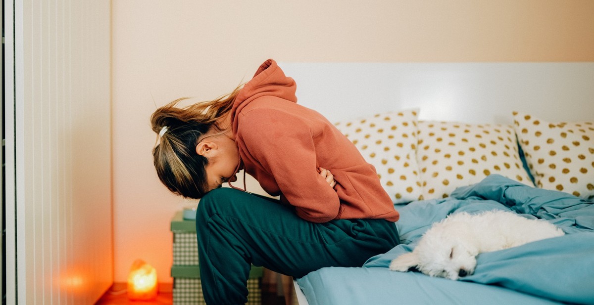 Young woman with painful menstruation resting in bed