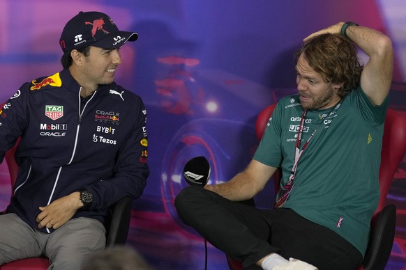 Aston Martin driver Sebastian Vettel of Germany, right, and Red Bull driver Sergio Perez of Mexico chat during a press conference at the Silverstone race track in Silverstone, Thursday, June 30, 2022. ...