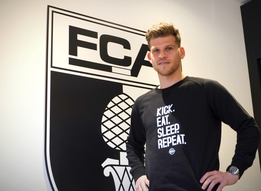 Florian Niederlechner posiert vorm FCA-Wappen in der VIP-Loge. 
