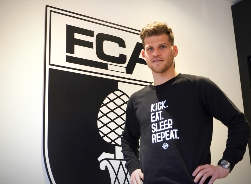 Florian Niederlechner posiert vorm FCA-Wappen in der VIP-Loge.