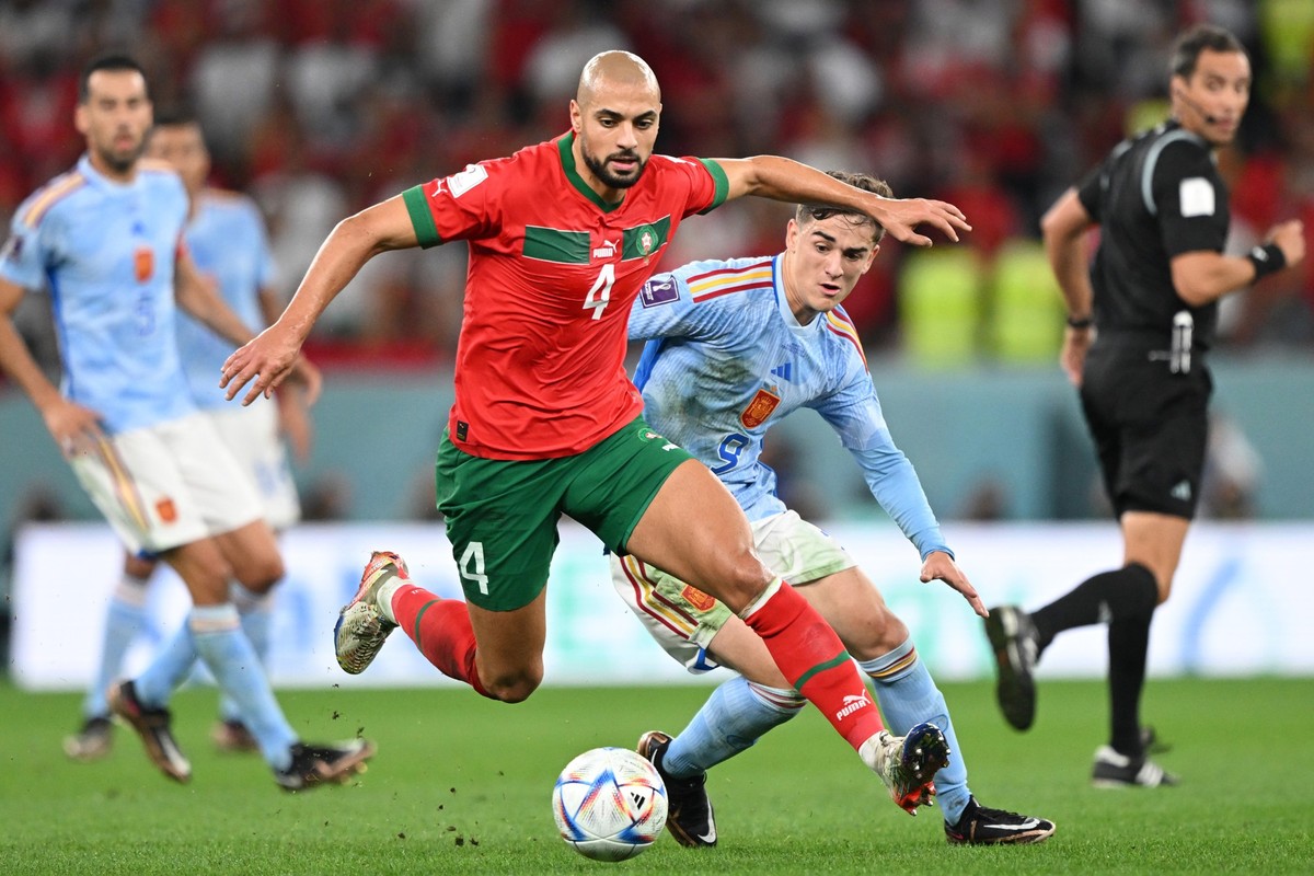 06.12.2022, Katar, Al-Rajjan: Fu�ball, WM, Marokko - Spanien, Finalrunde, Achtelfinale, Education City Stadion, Marokkos Sofyan Amrabat und Spaniens Gavi im Zweikampf. Foto: Robert Michael/dpa +++ dpa ...