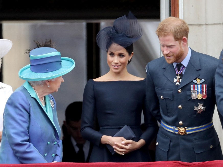 LONDON, ENGLAND - JULY 10: (L-R) Queen Elizabeth II, Meghan, Duchess of Sussex and Prince Harry, Duke of Sussex watch the RAF flypast on the balcony of Buckingham Palace, as members of the Royal Famil ...