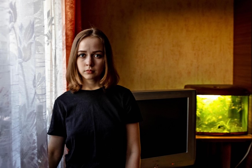 Portrait of a young teenage girl in a room by the window in the evening.