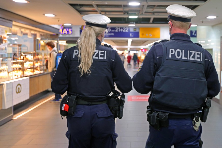 Zwei Bundespolizisten auf Streife an einem Bahnhof.