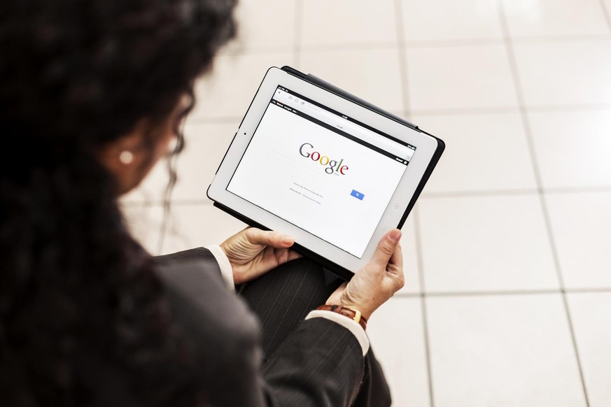 &quot;Pisa, Italy - November 10, 2012: Businesswoman holding a white iPad 2 with Google.com web site displayed on lcd screen. She is searching information on Google&quot;