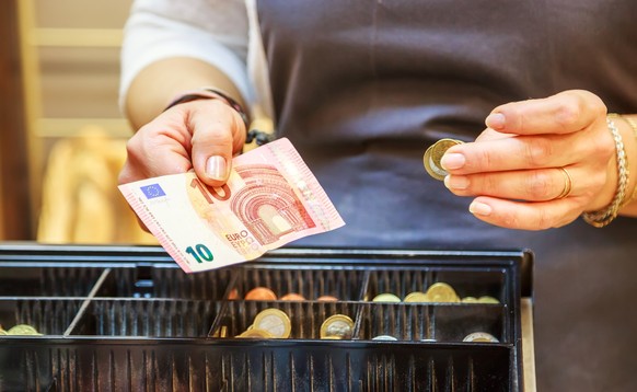 woman is paying In cash with euro banknotes