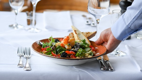 ARCHIV - 20.07.2021, Brandenburg, Potsdam: Ein Salat-Teller wird in einem Restaurant serviert. Essengehen wird im kommenden Jahr noch mal deutlich teurer. (zu dpa: &quot;Essengehen wird teurer - Mehrw ...