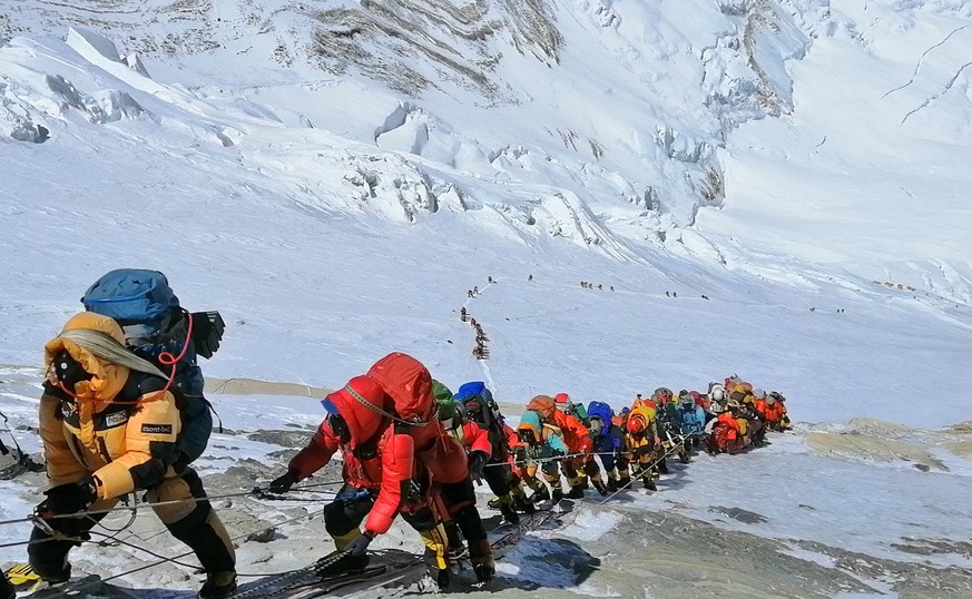 ARCHIV - 29.05.2019, Nepal, Mount Everest: In einer langer Schlange klettern Bergsteiger auf einem Pfad knapp unterhalb von Lager vier. (zu dpa: