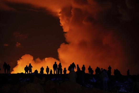 dpatopbilder - 16.03.2024, Island, Grindavík: Schaulustige beobachten die Rauchschwaden vulkanischer Aktivität zwischen Hagafell und Stóri-Skógfell. Zum vierten Mal in vier Monaten ist auf Island ein  ...