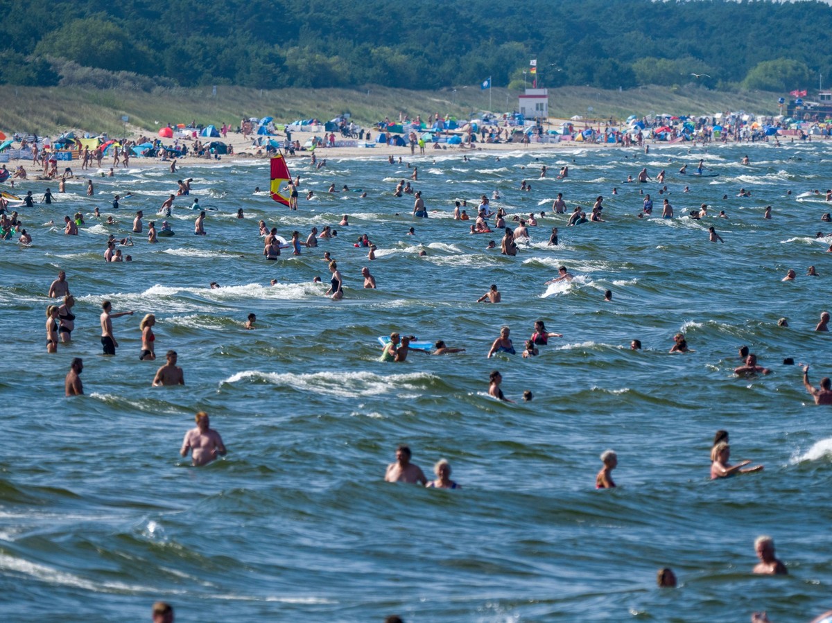 ARCHIV - 13.08.2025, Mecklenburg-Vorpommern, Zinnowitz: Touristen halten sich bei Sonne und hochsommerlichen Temperaturen im Ostseebad am Strand und im Wasser auf. (zu dpa: «Usedom: 82-Jähriger stirbt ...