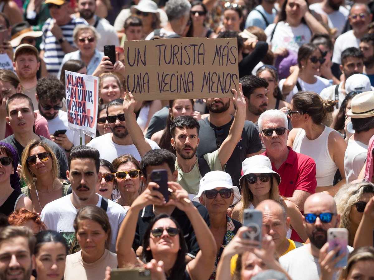 June 29, 2024, Malaga, Spain: A protester is seen holding up a placard expressing his opinion during a demonstration against mass tourism in the city, following recent protests in the Canary and Balea ...