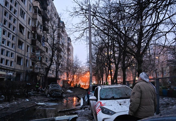 13.12.2023, Ukraine, Kiew: Ein Mann betrachtet das Wohnhaus, das bei einem Raketenangriff der russischen Armee in Kiew besch�digt worden ist. Am 13. Dezember griff die russische Armee die Hauptstadt d ...