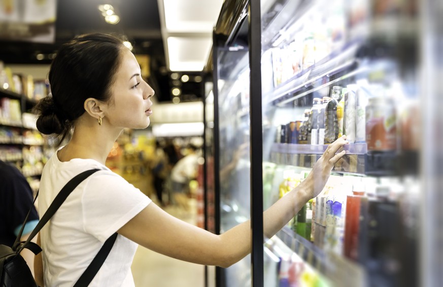Portrait of caucasian woman looking at product at grocery store. Happy hispanic girl shopping in supermarket reading product information. Costumer buying food at the market, woman lifestyle concept.
