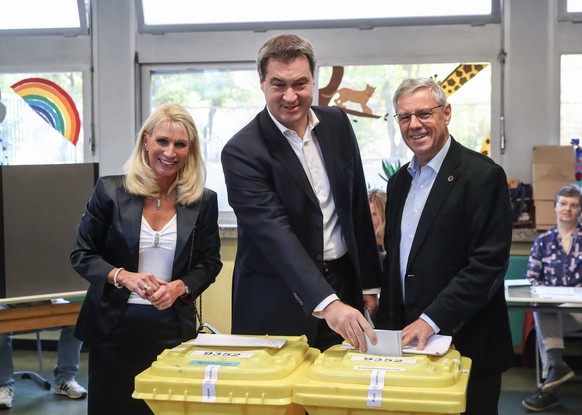 (181014) -- NUERNBERG, Oct. 14, 2018 -- German Christian Social Union s candidate and Bavarian governor Markus Soeder (C) cast his vote for local parliament election at a polling station in Nuernberg, ...