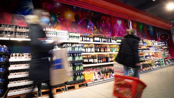 ARCHIV - 17.11.2020, Hamburg: Kunden sind vor dem Regal mit alkoholischen Getr