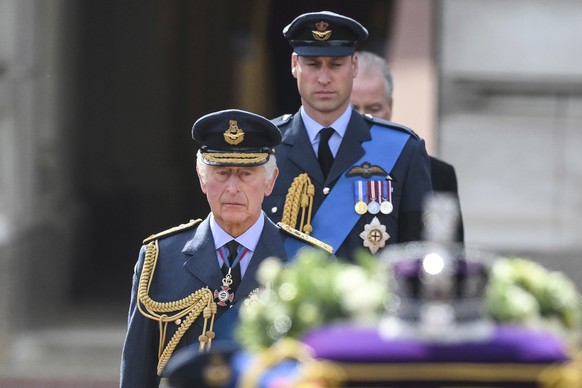 Britain's King Charles III and Prince William, Prince of Wales walk behind the coffin of Queen Elizabeth II, during a procession from Buckingham Palace to Westminster Hall in London, Wednesday, Sept.  ...