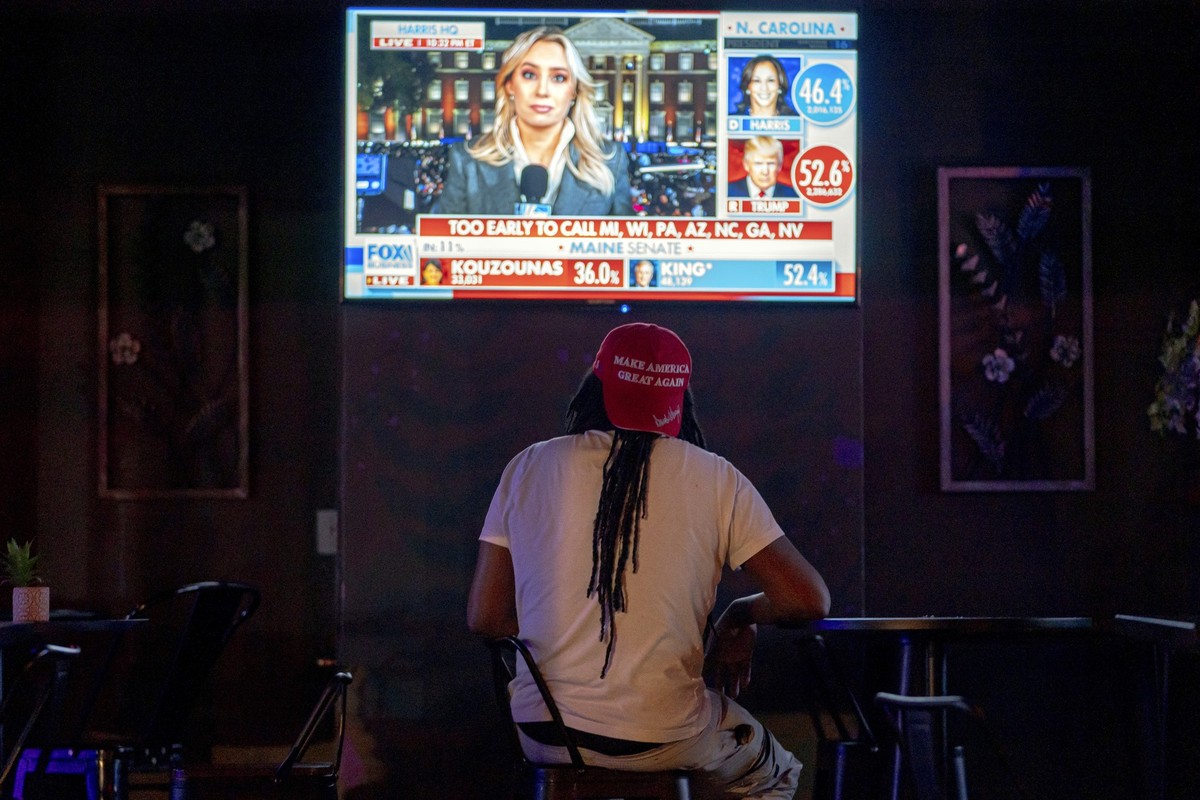 05.11.2024, USA, Washington D.C.: Ein Anhänger des republikanischen Präsidentschaftskandidaten und ehemaligen US-Präsidenten Trump verfolgt die Live-Übertragung der Wahl am Rande einer Wahlveranstaltu ...