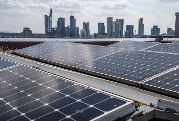 Solarmodule einer Photovoltaikanlage stehen auf dem Dach der Frankfurt School mit der Skyline der Stadt im Hintergrund. Die deutsche Industrie hält nach Angaben von BDI-Präsident Russwurm trotz der En ...