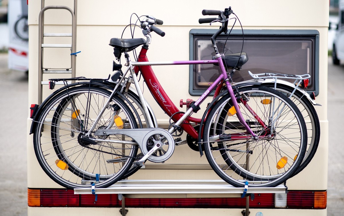 29.10.2022, Niedersachsen, Harlesiel: Fahrräder stehen auf einem Fahrradträger an einem Wohnmobil auf einem Stellplatz an der Mole. Trotz Preissteigerungen und kurzfristiger Buchungen blicken die nied ...